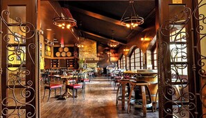 Un restaurant spacieux avec de hauts plafonds, des murs en briques apparentes et de grandes fenêtres.