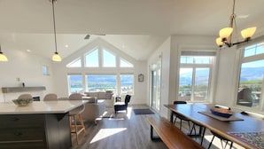 A spacious kitchen with a large island, dining area, and a view of the outdoors.