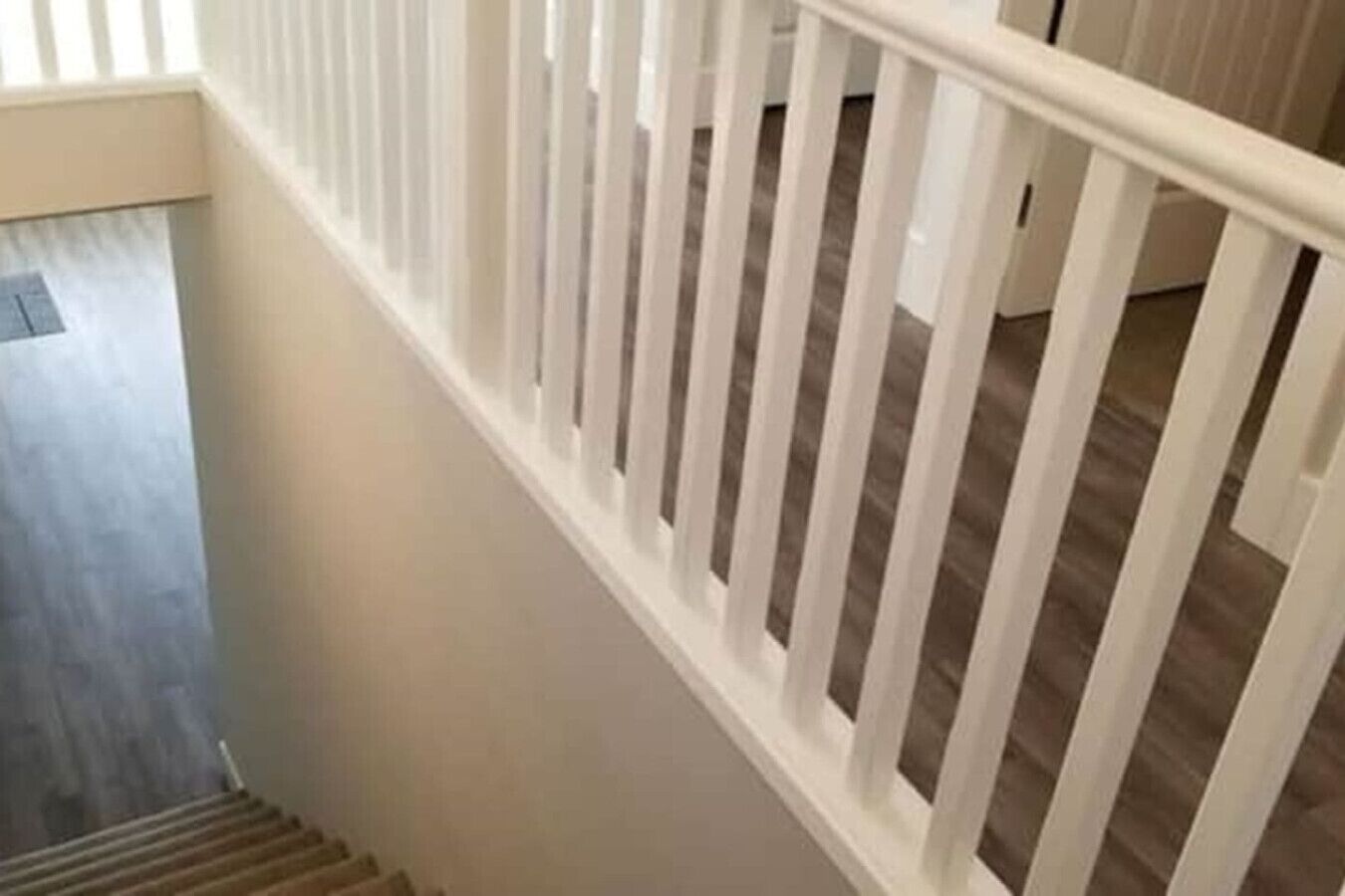 Eine Treppe mit weißen Geländern und Holzboden.