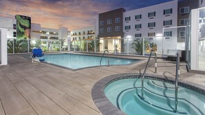 A hotel pool area with a blue chair, a small hot tub, and a view of the building's exterior. - Club Wyndham Anaheim - 2 Bedroom (Anaheim)