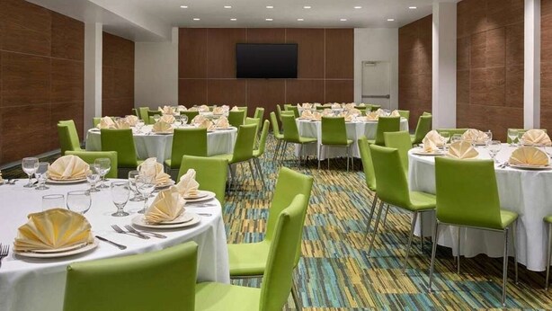 A conference room with multiple tables, green chairs, and a large screen on the wall. - Club Wyndham Anaheim - 2 Bedroom (Anaheim)