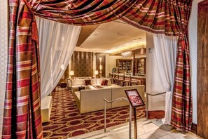 Un hall de hotel con una zona de estar, un bar y vistas al área del bar.