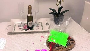 A table with a bottle of wine, glasses, a tray, and a decorative item with a green star. - Rosetta's Experience (Roma)