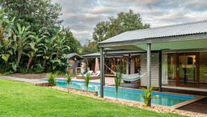 A modern house with a pool, outdoor seating, and lush greenery. - Hamptons Inspired Luxury (Mount Martha)
