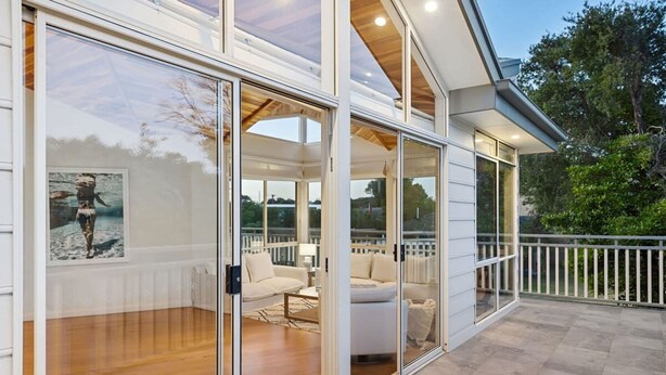 A modern house with a glass-enclosed porch, wooden flooring, and a white railing. - Blairgowrie Beachside Retreat Solar Heated Pool (Blairgowrie)