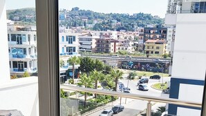 Vista desde una ventana con vista a un paisaje urbano, edificios, un estacionamiento y una carretera.