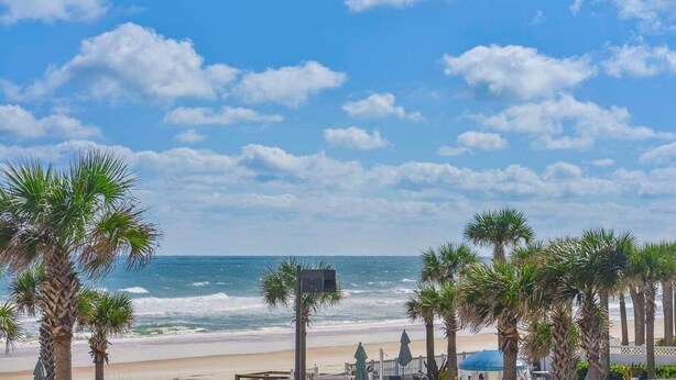 A beach with palm trees and a clear sky.