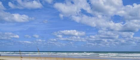 Una playa con cielo despejado y olas.