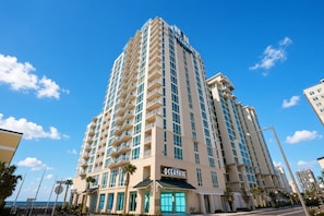 Un hôtel de grande hauteur doté de nombreux balcons, d’une enseigne bien visible indiquant « OCEANAIRE » et offrant une vue sur l’océan.