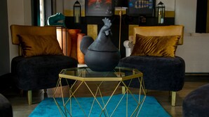 Una sala moderna con dos sofás oscuros, una mesa de centro de vidrio y jarrones decorativos.