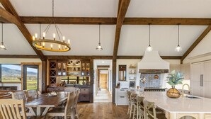 A spacious kitchen with wooden floors, a central island, and a view of the outdoors.