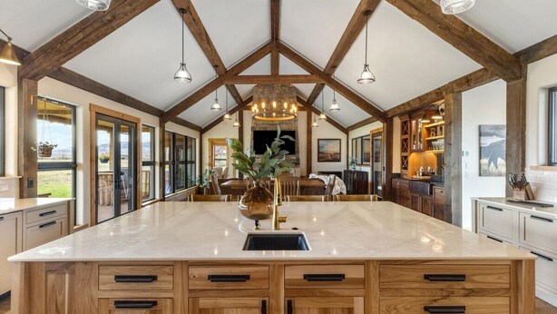 A spacious kitchen with a large island, wooden cabinetry, and pendant lighting.