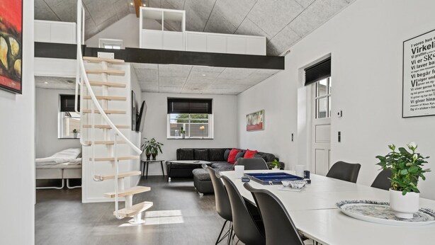 Et moderne interiør med trappe, spiseområde og opholdstue.
