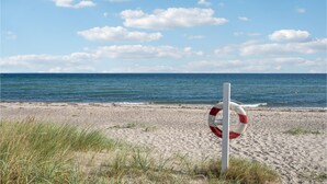 En redningskrans på en sandstrand med havet i baggrunden.
