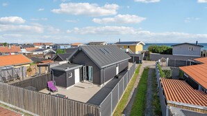 Et boligområde med huse, klar himmel og havudsigt.