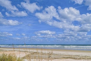 Una playa con cielo despejado y olas.