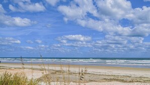Una spiaggia con cielo sereno e onde.