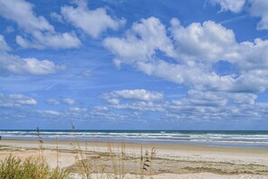 En strand med klart himmel og bølger.
