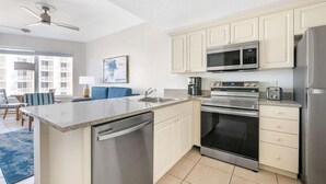Una cucina moderna dotata di lavastoviglie, forno, microonde e frigorifero.
