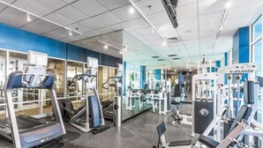 Une salle de sport équip ée de tapis de course, de vélos elliptiques et de matériel de musculation.
