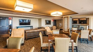 Eine Hotelhalle mit Billardtisch, Sitzgelegenheit und Bar/Lounge mit Fernsehern.