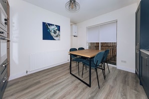 Una cocina moderna con una mesa de comedor, sillas y un equipo de aire acondicionado instalado en la pared.