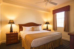 A hotel room with a bed, two bedside tables, a ceiling fan, a window with curtains, and a carpeted floor. - Orlando | Family Lake Retreat | Pool + Hot Tub | 2BR Condo (Orlando)
