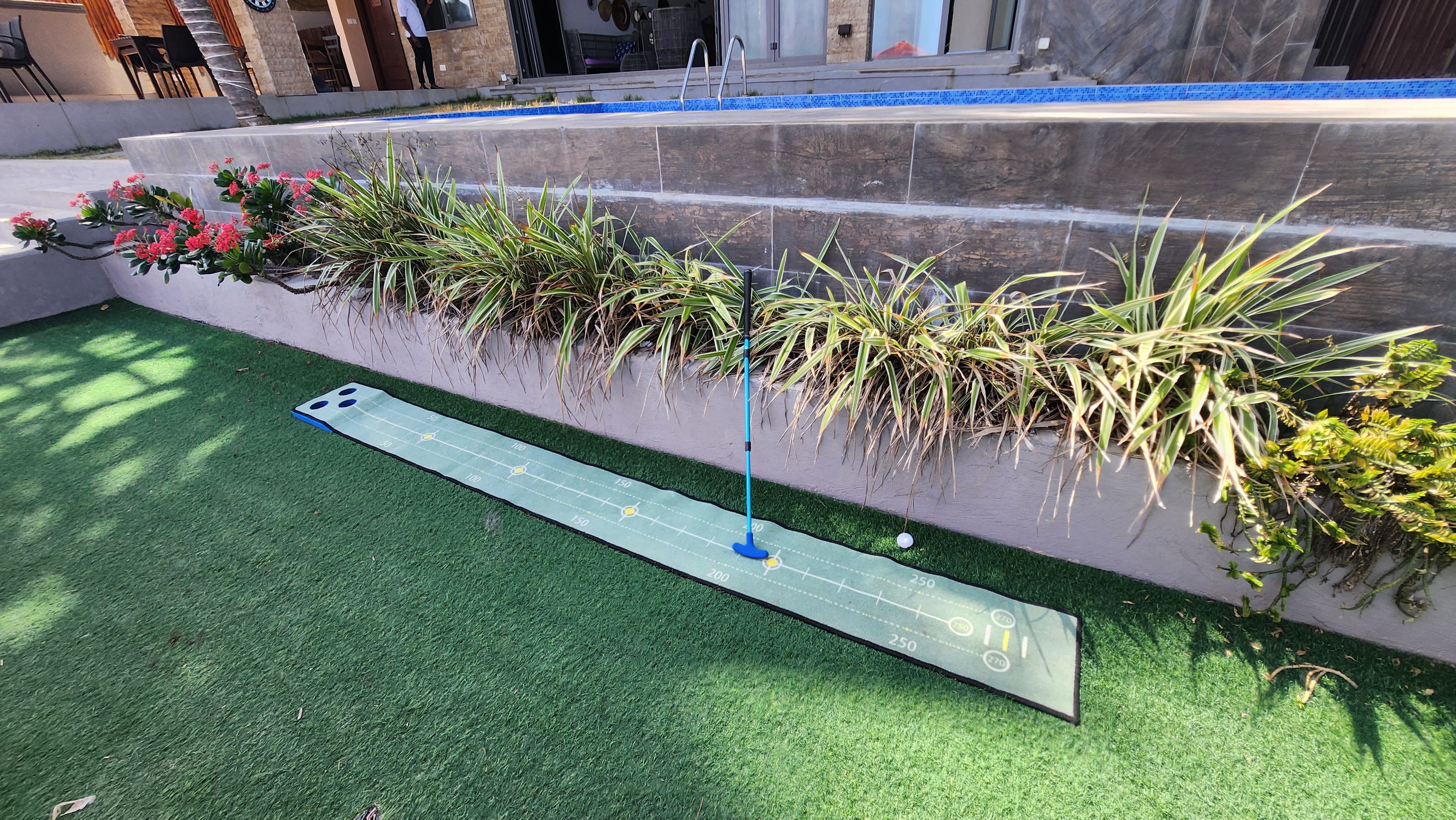 A miniature golf course with a putting green, a blue flagstick, and a scorecard.