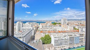 A cityscape with a view of the sea and mountains in the distance. - L'Horizon - 3 ch climatisé avec vue mer incroyable (Marseille)