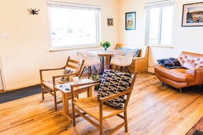 Relax in this open-plan living and dining area with a round dining table and comfortable seating for four.