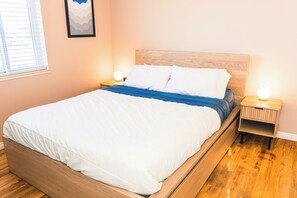 Cozy bedroom with a wooden bed, bedside tables, and a framed picture on the wall.