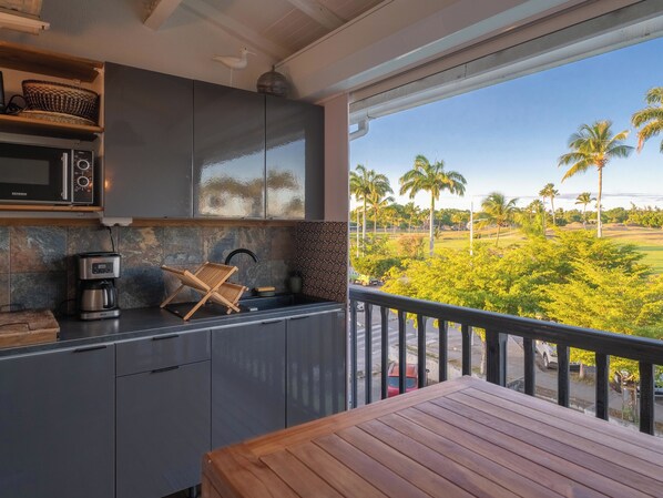 Una cocina moderna con un amplio ventanal que da a un paisaje tropical.