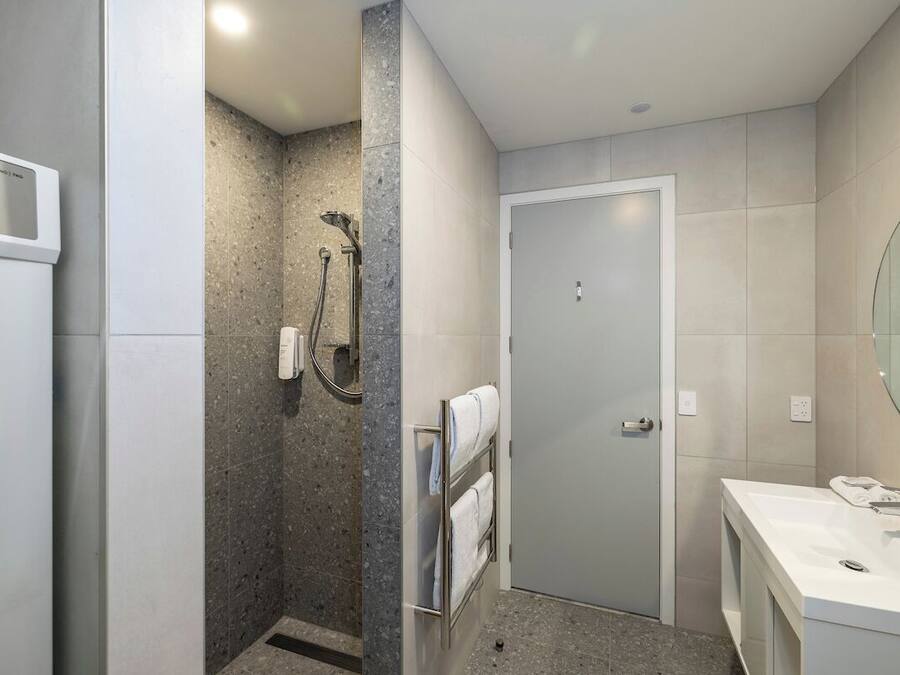 Un baño moderno con ducha, inodoro y lavamanos.