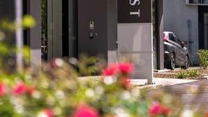 A modern building with a glass facade and a sign reading "QUEST". - Quest on Cambridge  (Christchurch)