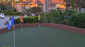 A golf course with flags and a building in the background.