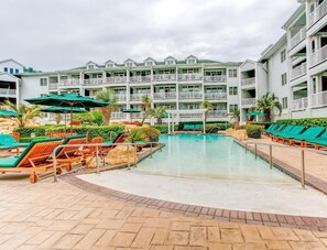 A hotel with a pool area, multiple balconies, and outdoor seating. - Virginia Beach | Couples Ocean Coast Getaway | Pool + Hot Tub (Virginia Beach)