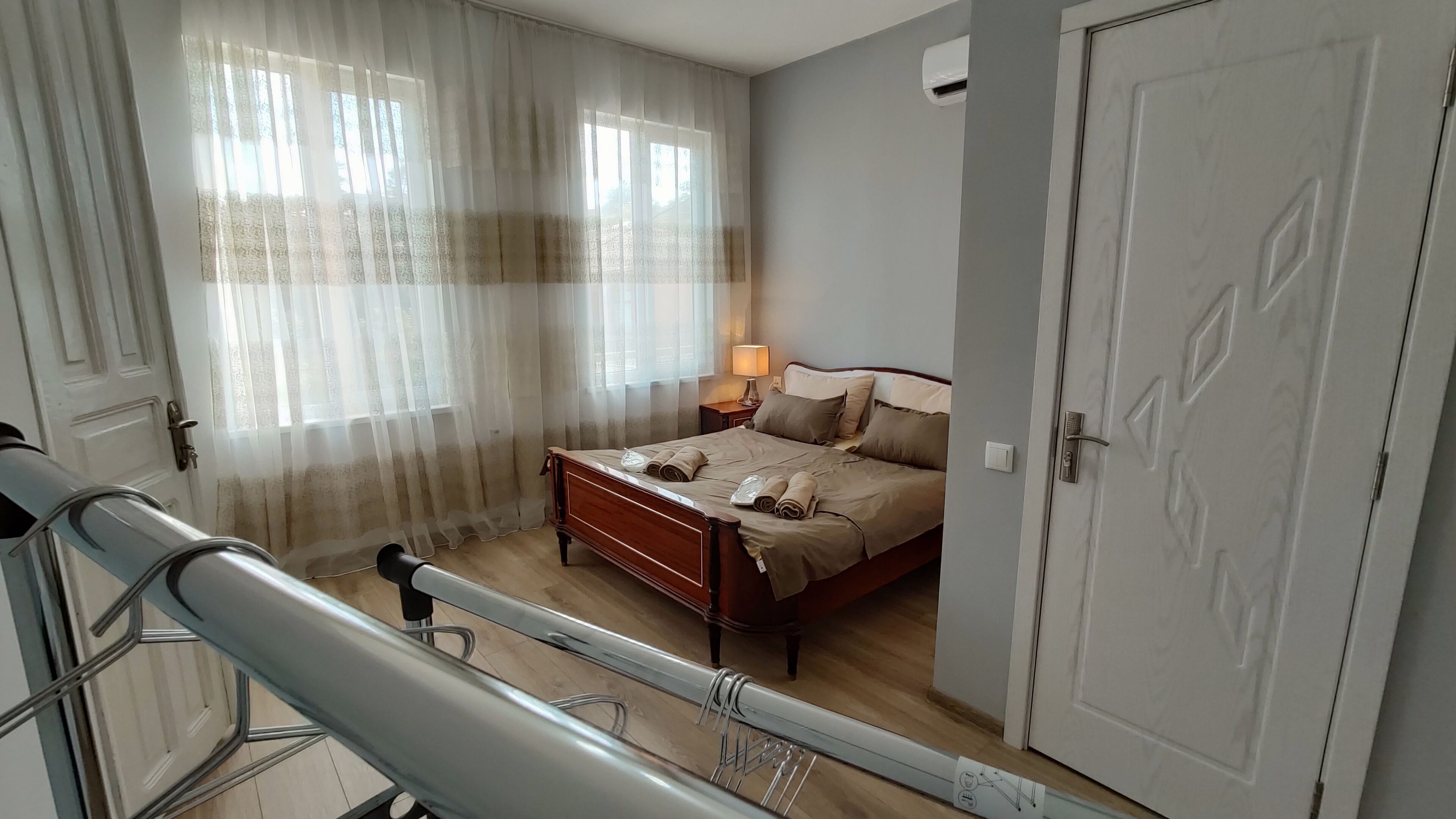 Ein Schlafzimmer mit einem Bett, einem Nachttisch, einer Lampe und einer Tür.