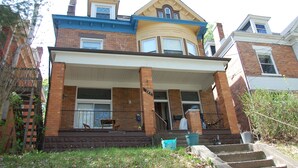 A two-story brick house with a front porch, a garage, and a visible number 145.