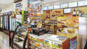 A breakfast counter with a variety of food items and a refrigerator filled with beverages.