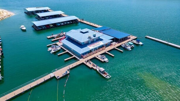 A marina with multiple docks and a central building with a sign. - Lakeside Charm at Casa Carmen by the Golf Course (Point Venture)