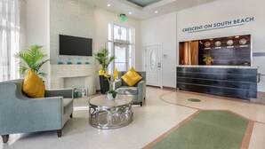 A lobby with a reception desk, seating area, and a fireplace.