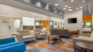 Eine moderne Lobby mit Check-in-Bereich, Sitzgelegenheiten und einer Rezeption.