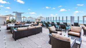Une terrasse sur le toit avec des sièges extérieurs, un foyer et une vue sur l’océan.