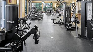 Une salle de sport équipée de divers appareils d’exercice, notamment des tapis de course et des appareils de musculation.