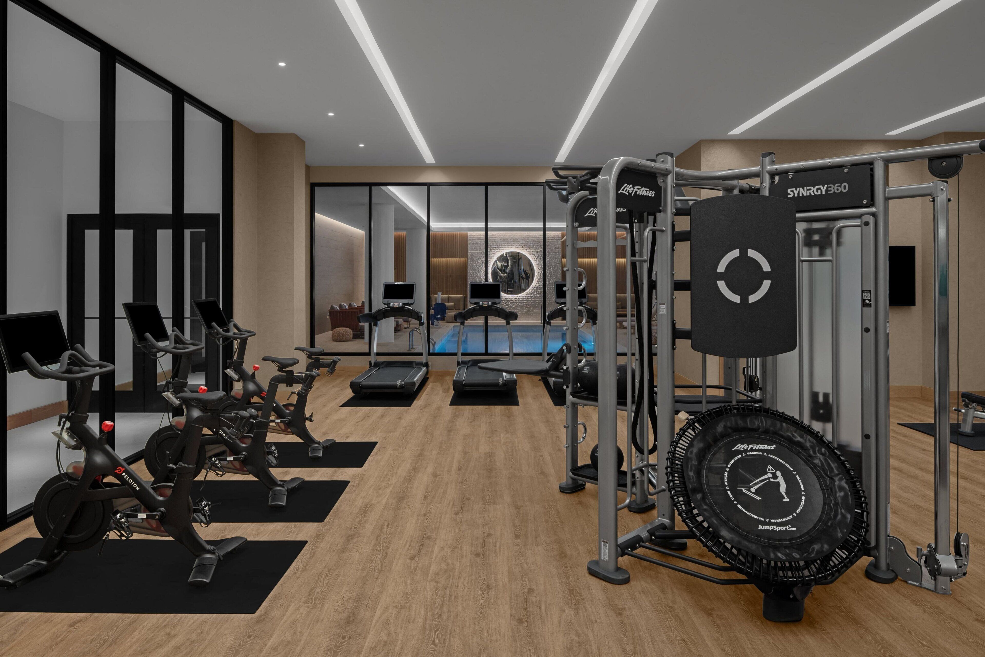 A modern gym with stationary bikes, treadmills, and a jump rope station.