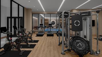 A modern gym with stationary bikes, treadmills, and a jump rope station.
