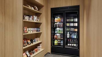 A storage room with wooden shelves and a black beverage refrigerator.
