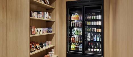 A storage room with wooden shelves and a black beverage refrigerator.