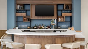 Una cocina moderna con barra, que incluye un televisor grande, estantes de madera y taburetes de bar.