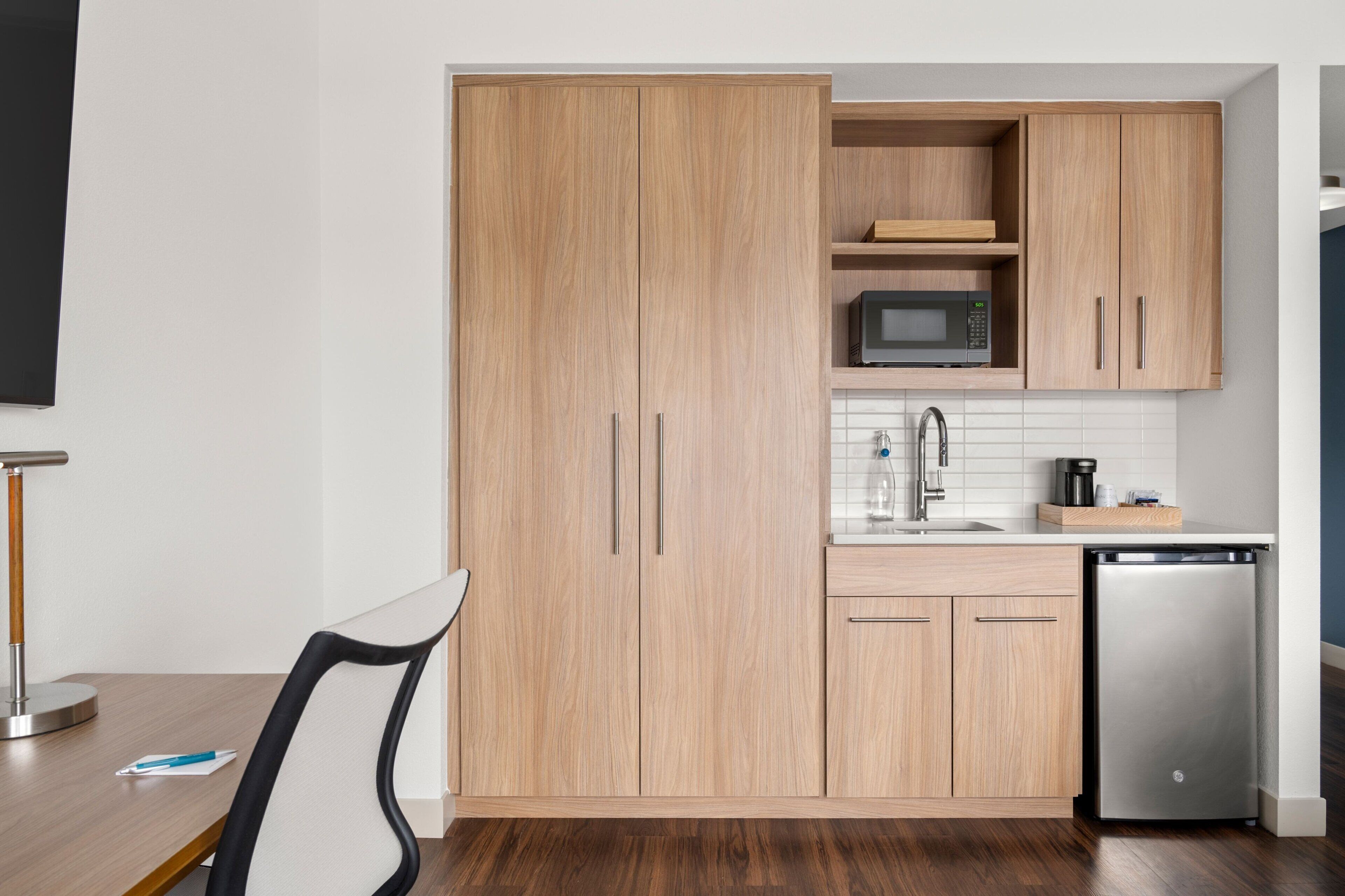A modern kitchen with wooden cabinets, a microwave, a sink, and a dishwasher.